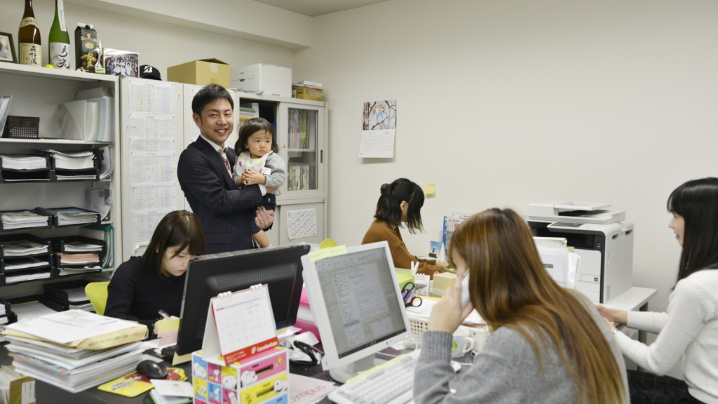 女性スタッフの子供を抱く福井社長